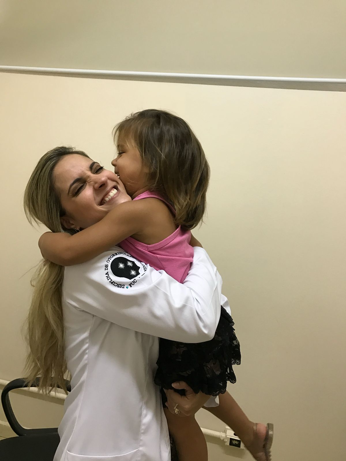 Dra. Larissa Richter sorrindo e abraçando uma criança